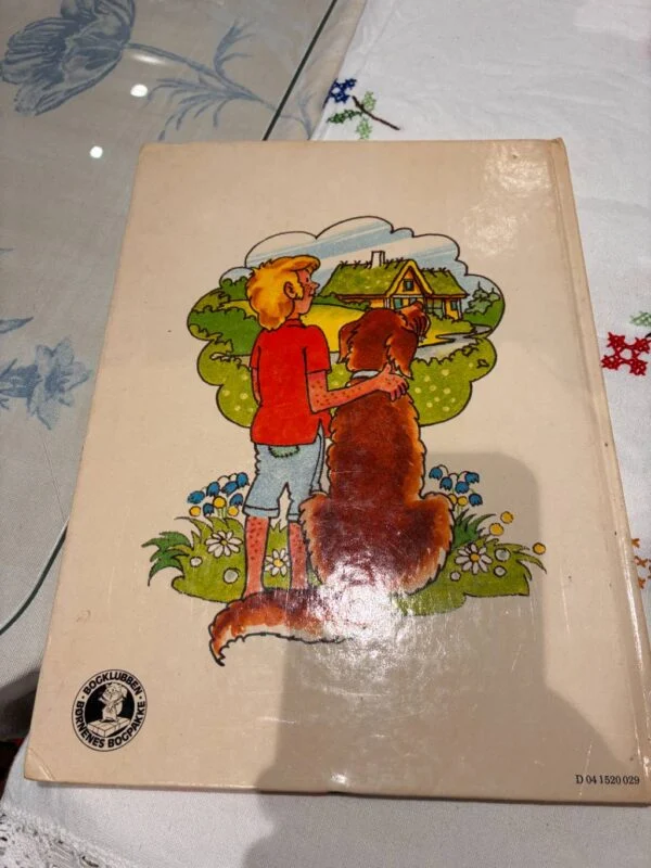 Bagside af bogen med illustration af en dreng og en hund foran en bondegård