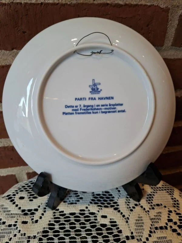 Bagside af havneplatten 1983 med Millhouse Danmark, teksten Parti fra havnen, 7. årgang og metaltråd til ophæng.