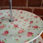 Nærbillede af kagefadets øverste tallerken med rosa rosemønster