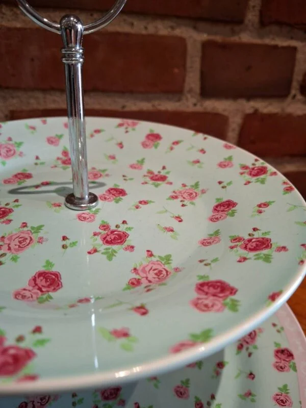 Nærbillede af kagefadets øverste tallerken med rosa rosemønster