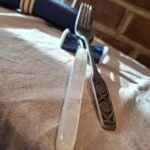 Kniv med hvid perlemorsskaft og metallisk dekoration