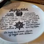Sildetallerken med detaljerede illustrationer og opskriftstekst