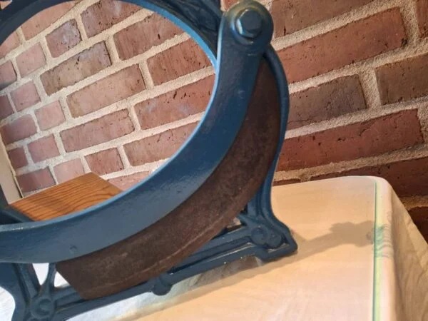 Buet kniv med mørke rustfarvede områder i en blå brødskærer med løftearm.