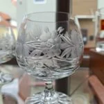 Nærbillede af et klart glas med frostet blomster- og bladmønster.