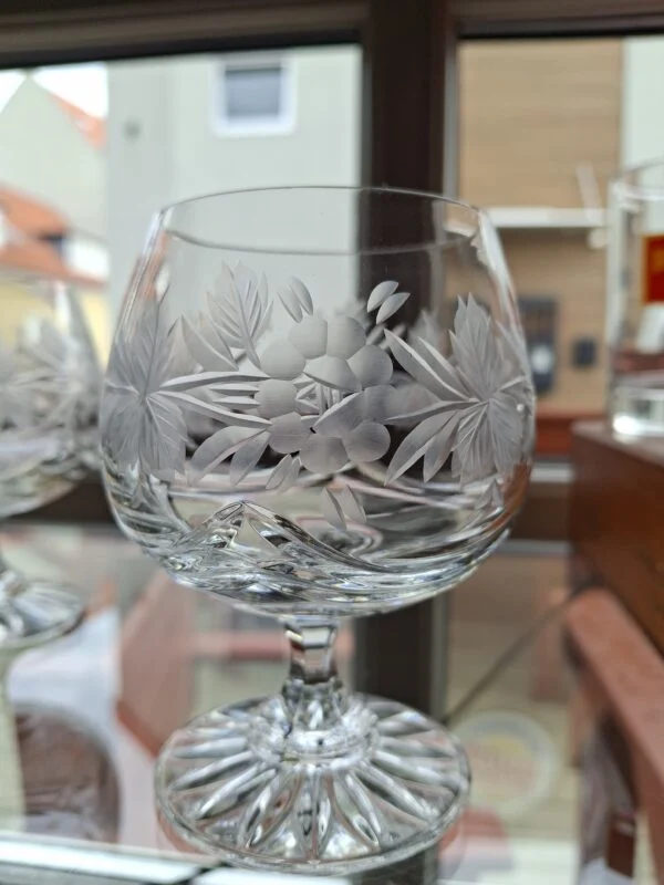 Nærbillede af et klart glas med frostet blomster- og bladmønster.