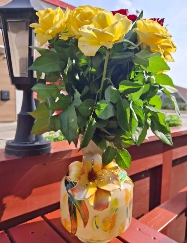 Vasen med gul blomsterdekoration står med en buket gule roser.