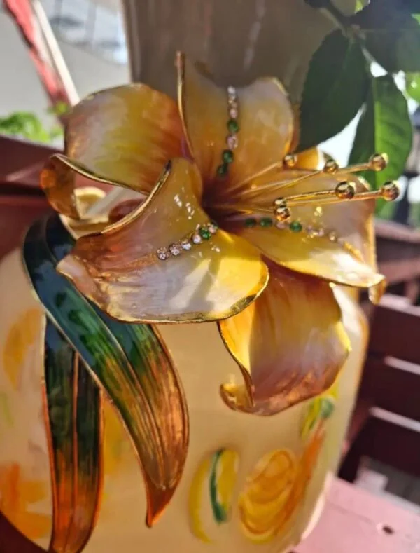 Den gule blomsterdekoration med guldfarvede konturer og små blanke detaljer.