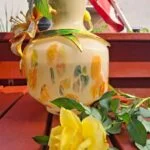 Lys vasekrop med farvede felter og den påsatte blomsterdekorations bagside.
