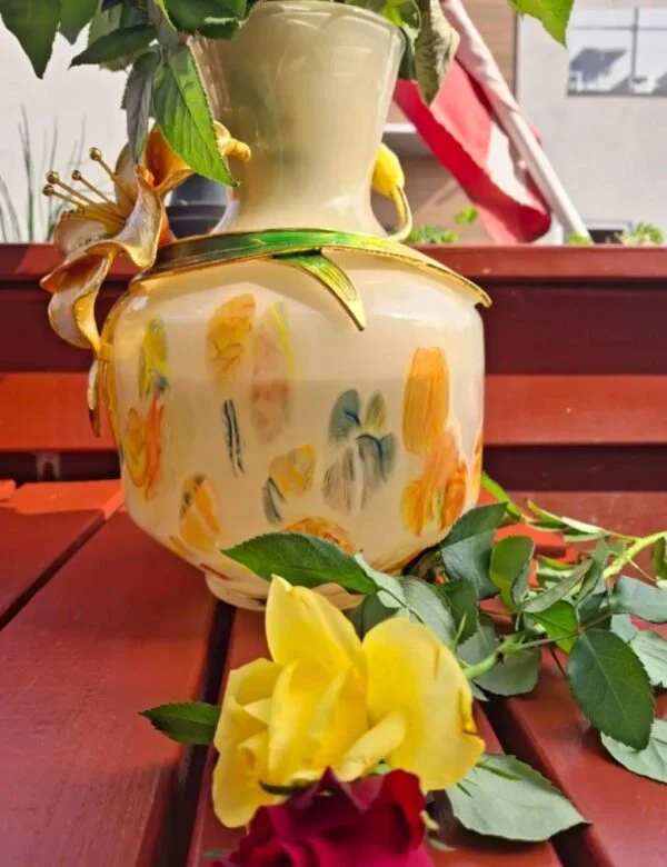 Lys vasekrop med farvede felter og den påsatte blomsterdekorations bagside.