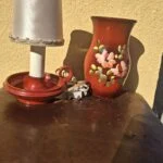 Rød bordlampe med skærm ved siden af en vase, som sælges separat