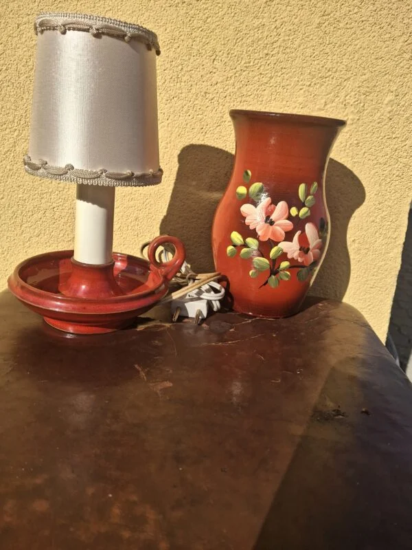 Rød bordlampe med skærm ved siden af en vase, som sælges separat