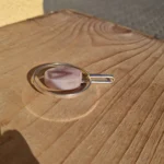 Vedhænget set fra siden med åben oval metalramme og aflangt ophæng