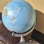 Globus med Australien, New Zealand og Stillehavet samt sølvfarvet bue og fod