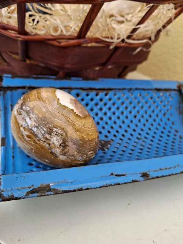 Pynteæg med bølgede bånd i beige, hvid og brune nuancer