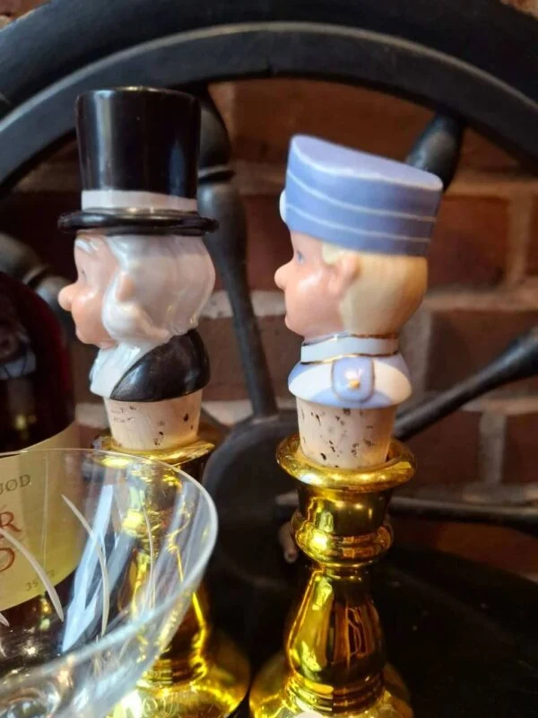To propper med figurhoveder og korkdele, set fra siden.