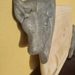 Detalje af oksehovedets horn og metaloverflade med mørke og brunlige områder