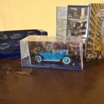 Blå Tintin modelbil fra Tintin i Amerika under klar kappe med konfetti, æske og hæfte