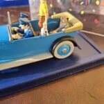 Terry og den siddende passager ved siden af Tintin i paradebilen