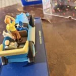 Åben blå Tintin-paradebil set bagfra med figurer og nedfoldet kaleche