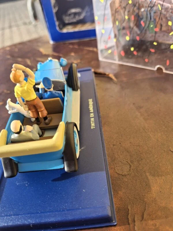 Åben blå Tintin-paradebil set bagfra med figurer og nedfoldet kaleche