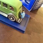 Tintin holder fast ved reservehjulet bag på Mitsuhiratos grønne sedan