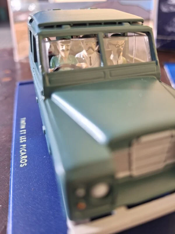 Grøn Tintin-Land Rover på blå sokkel med figurer i kabinen