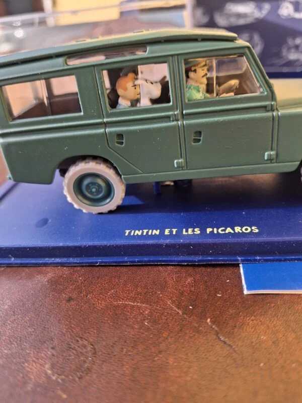 Tintin og Terry ved sidevinduet over soklen mærket Tintin et les Picaros
