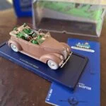Åben rosa-brun Ford V8 med Tintin og uniformerede figurer på blå sokkel