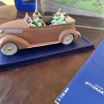 Rosa-brun Tintin-Ford med lyse hjul og nedfoldet kaleche