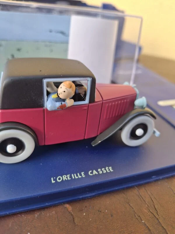 Nærbillede af Tintin ved sideruden på den røde modelbil