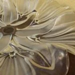 Nærbillede af glasfadets blade, blomst og bølgede kant