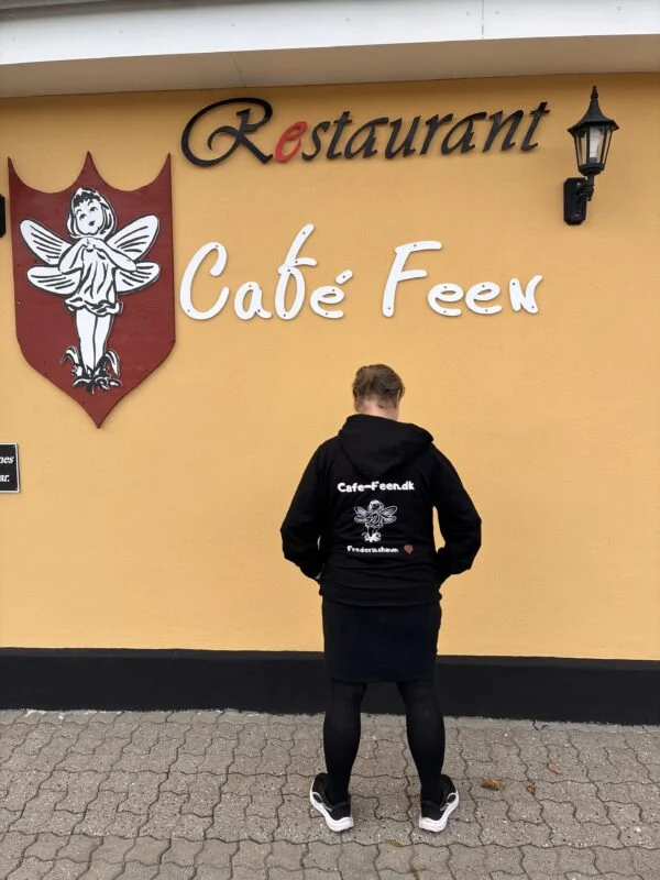 Hoodiens rygtryk med fe og rødt hjerte foran Café Feen