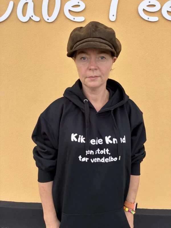 Kiksede Knud hoodie vist forfra ved Café Feens gule facade