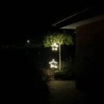 Stålstjerne på pind med lys som dekoration